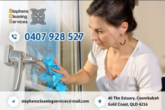 A hand holding a squeegee cleaning a window on a high-rise building.
